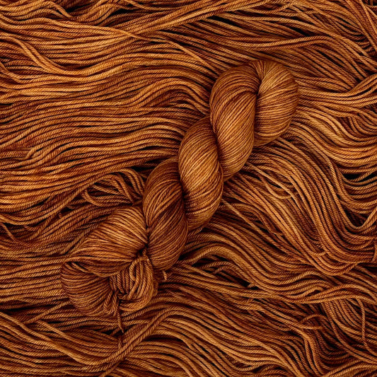 Close-up of brown yarn with a skein on a textured brown background